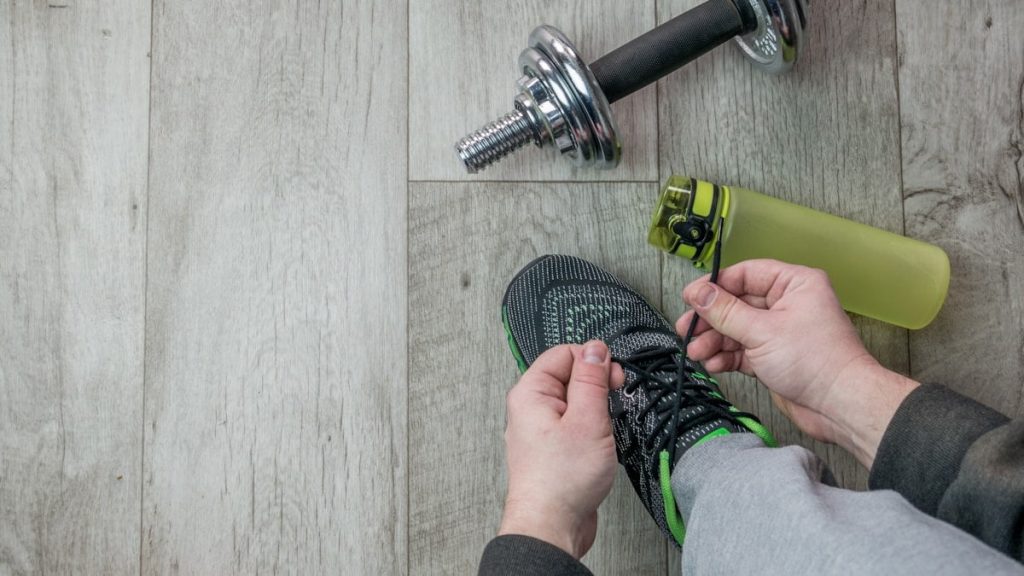 Fitness objects isolated on wooden background. Gray Sneakers, dumbbells and water bottle. Active, healthy lifestyle, sport, fitness, and objects concept. More of my photos and videos Adobe Stock:http://bit.ly/3RqlciK More of my photos and videos Shutterstock: https://www.shutterstock.com/g/ALEKSANDRBERDYUGIN My email: bermix999@gmail.com